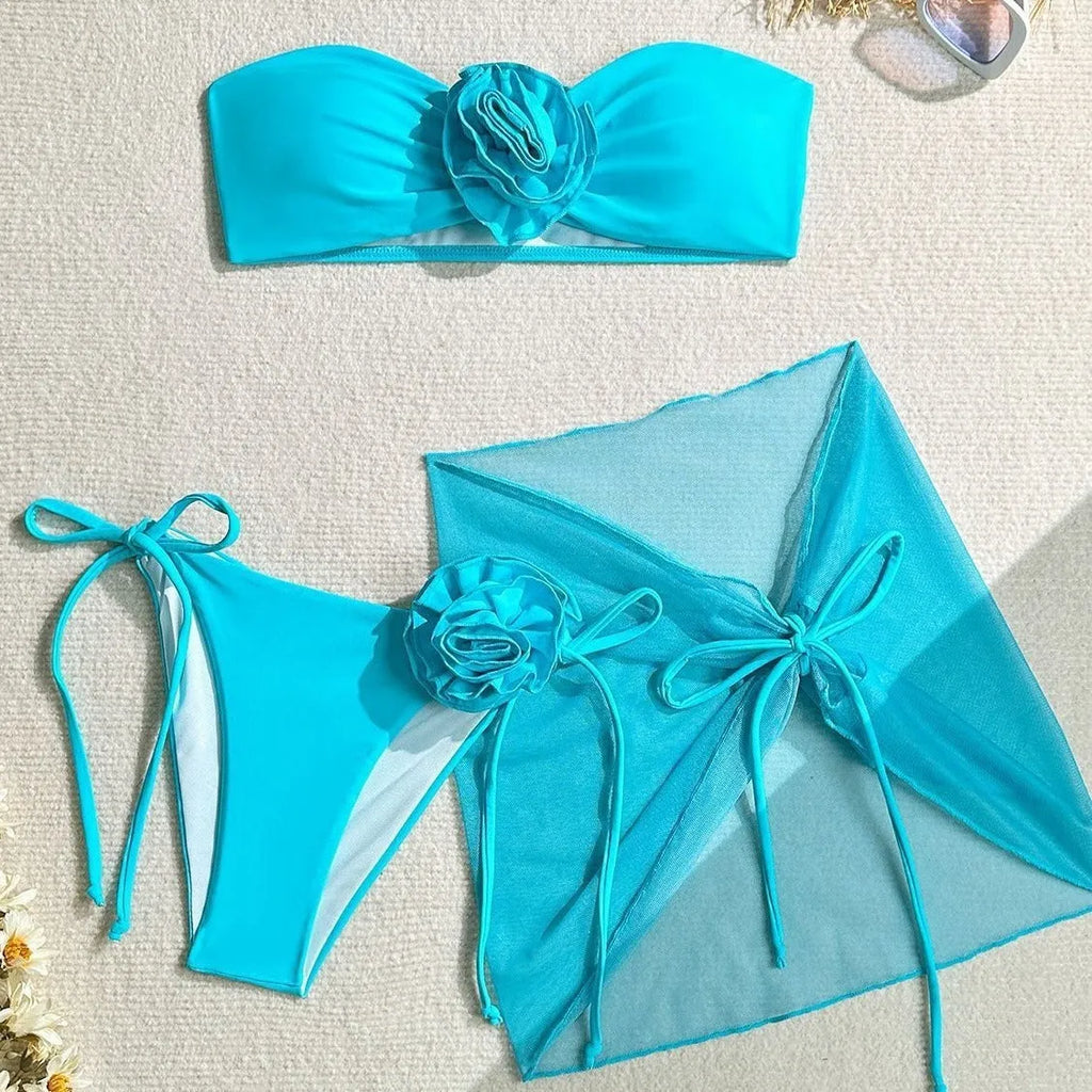 Women's pink bikini set with flower detail on tube top and a separate matching skirt.