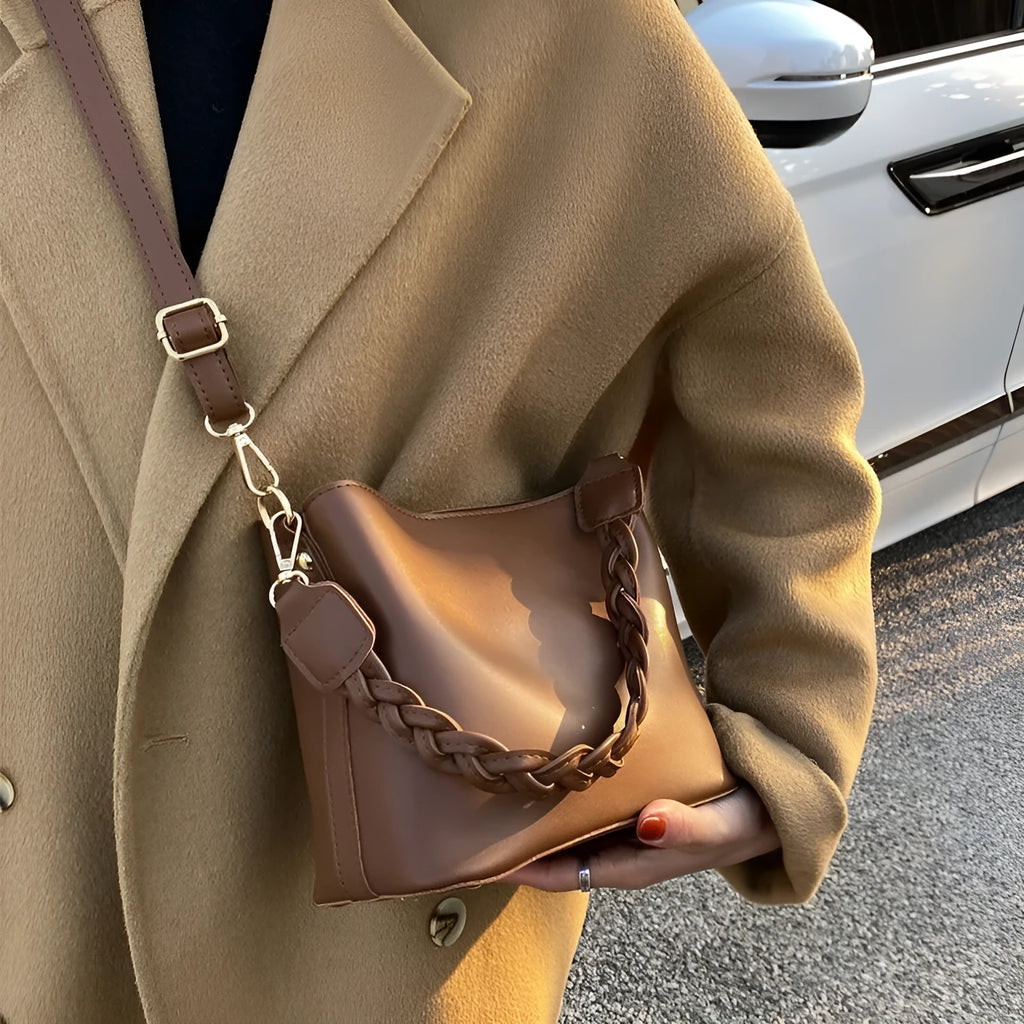 Retro woven PU leather crossbody bucket bag in an androgynous style.
