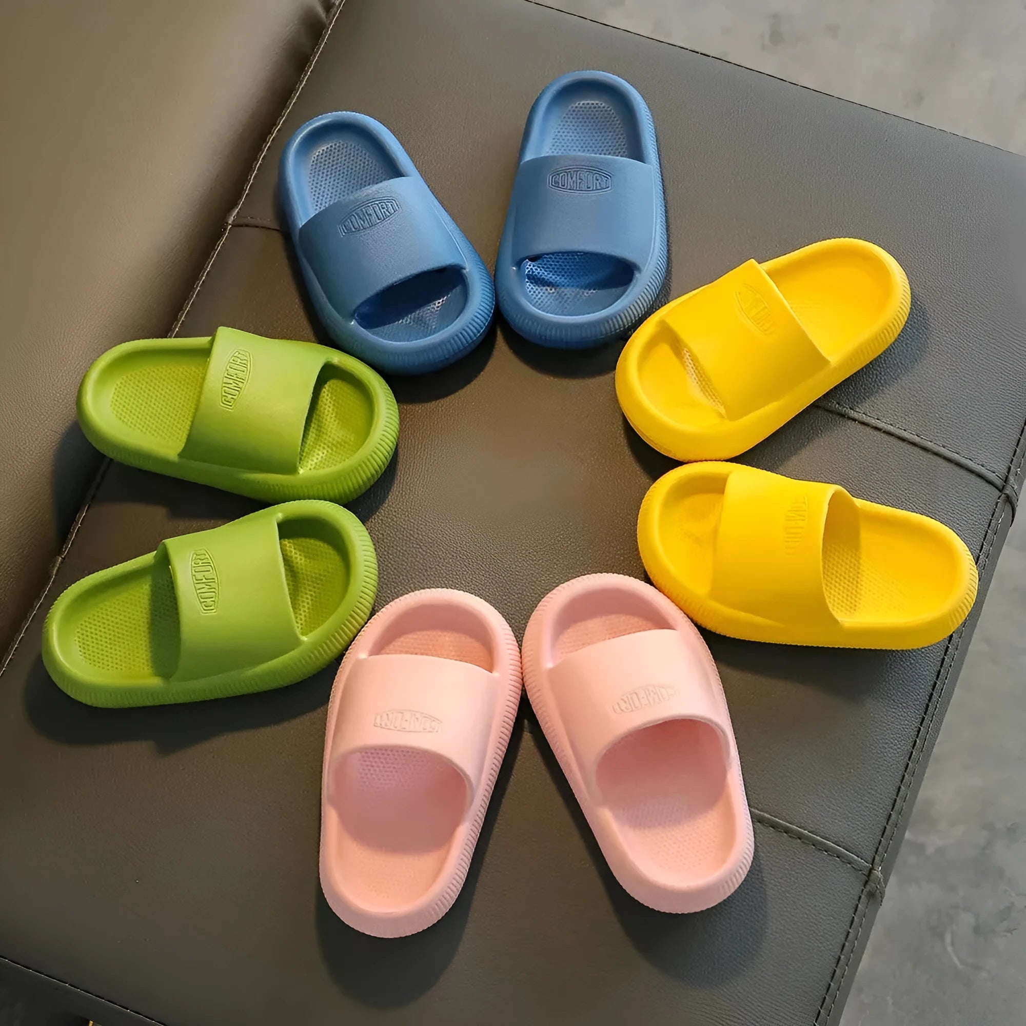 Children's colourful EVA slippers with a textured non-slip sole, shown in blue, green, orange, pink, and yellow.