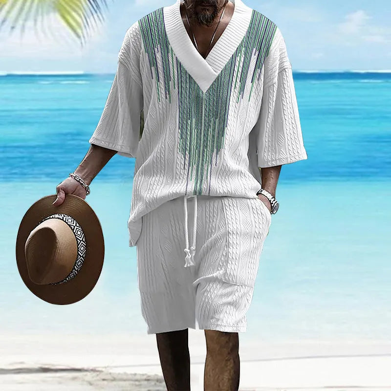 A man wearing a printed drop-shoulder knitted top and matching shorts from a casual two-piece loungewear set.