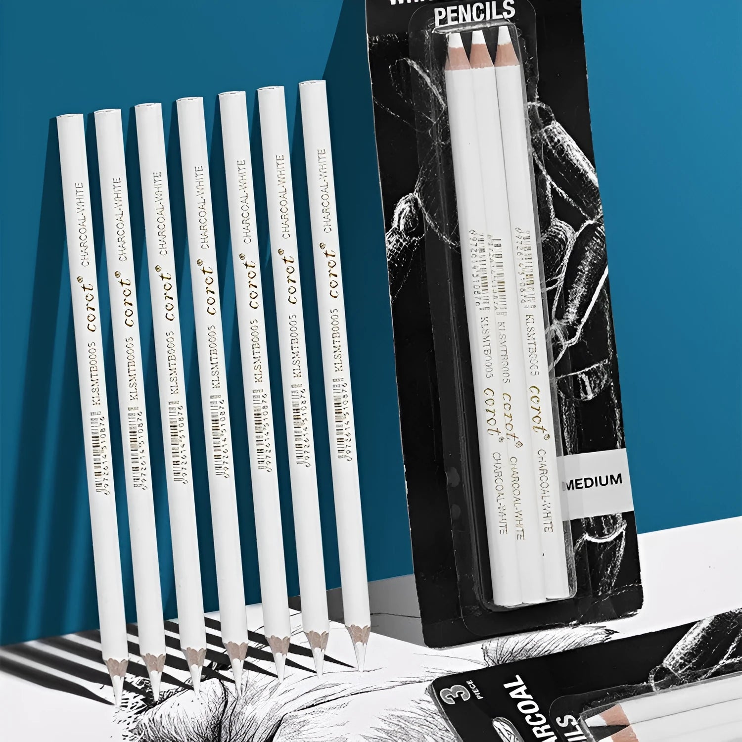 Three white charcoal sketching pencils with wooden casings and a visible refillable brush tip.