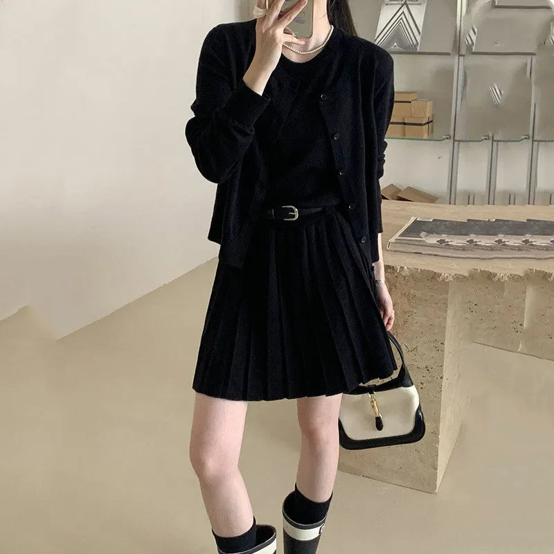 Women's grey art retro knitted vest skirt and long sleeve cardigan two-piece set on a hanger.