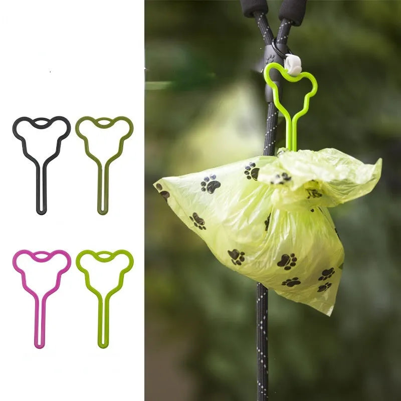 A hands-free dog poop bag holder with a fixed clip and adjustable black Velcro strap attached to a leash.