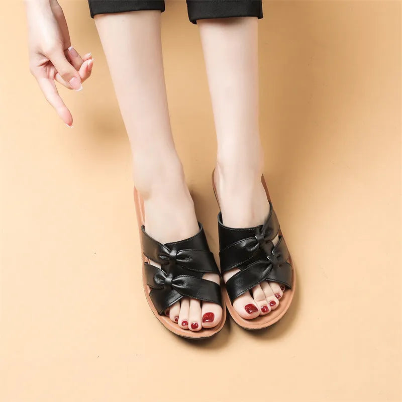 Women's beige cowhide leather slippers with a non-slip sole shown on a white background.