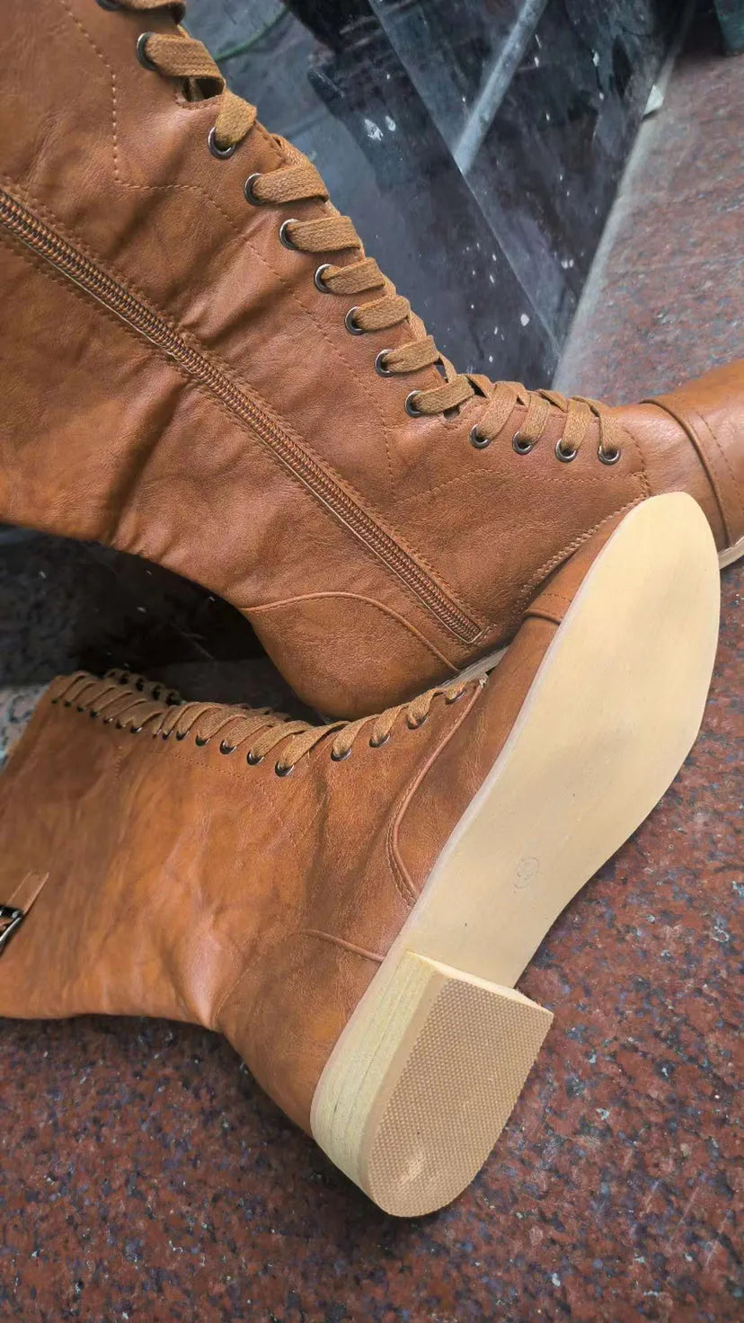 Women's black knee-high boots with a cross-strap buckle and elastic back panel.