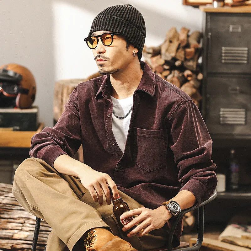 Man wearing a loose-fit red corduroy shirt jacket, showcasing its textured fabric and casual style.
