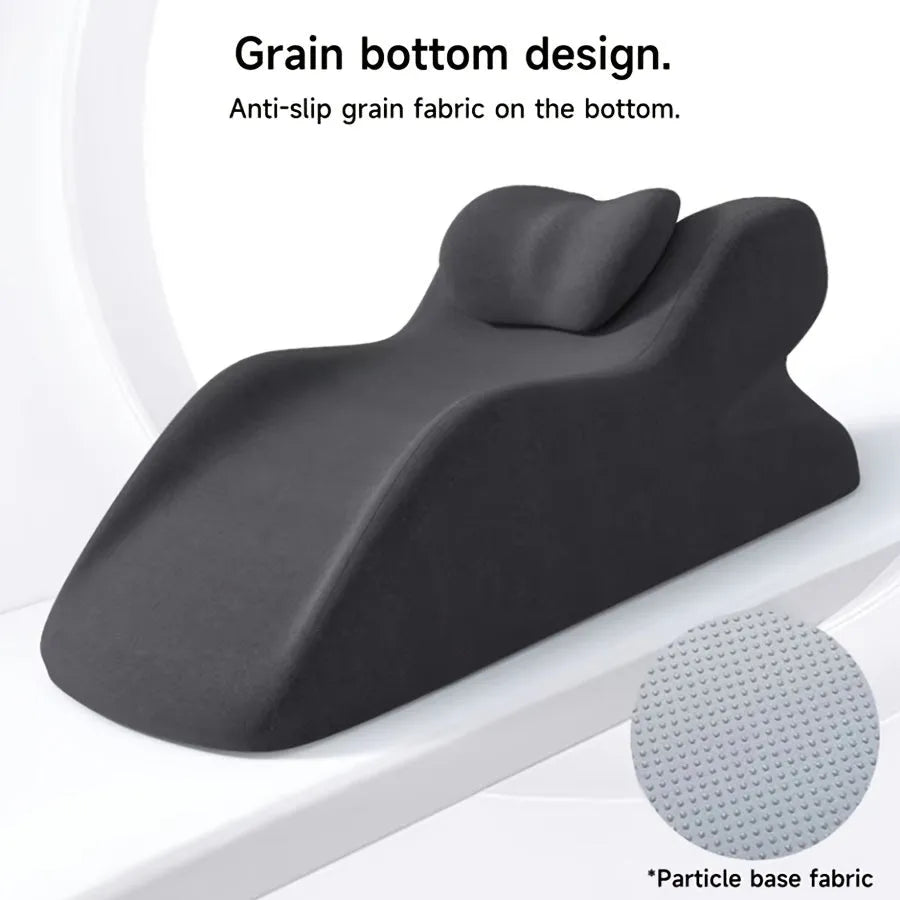 A prone position stomach sleeping pillow shown in a light grey colour, designed for use while reading in bed.