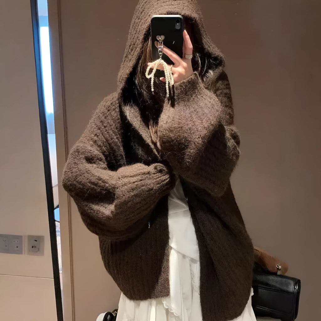 A woman wearing a brown retro-style hooded cardigan with thick knit fabric.