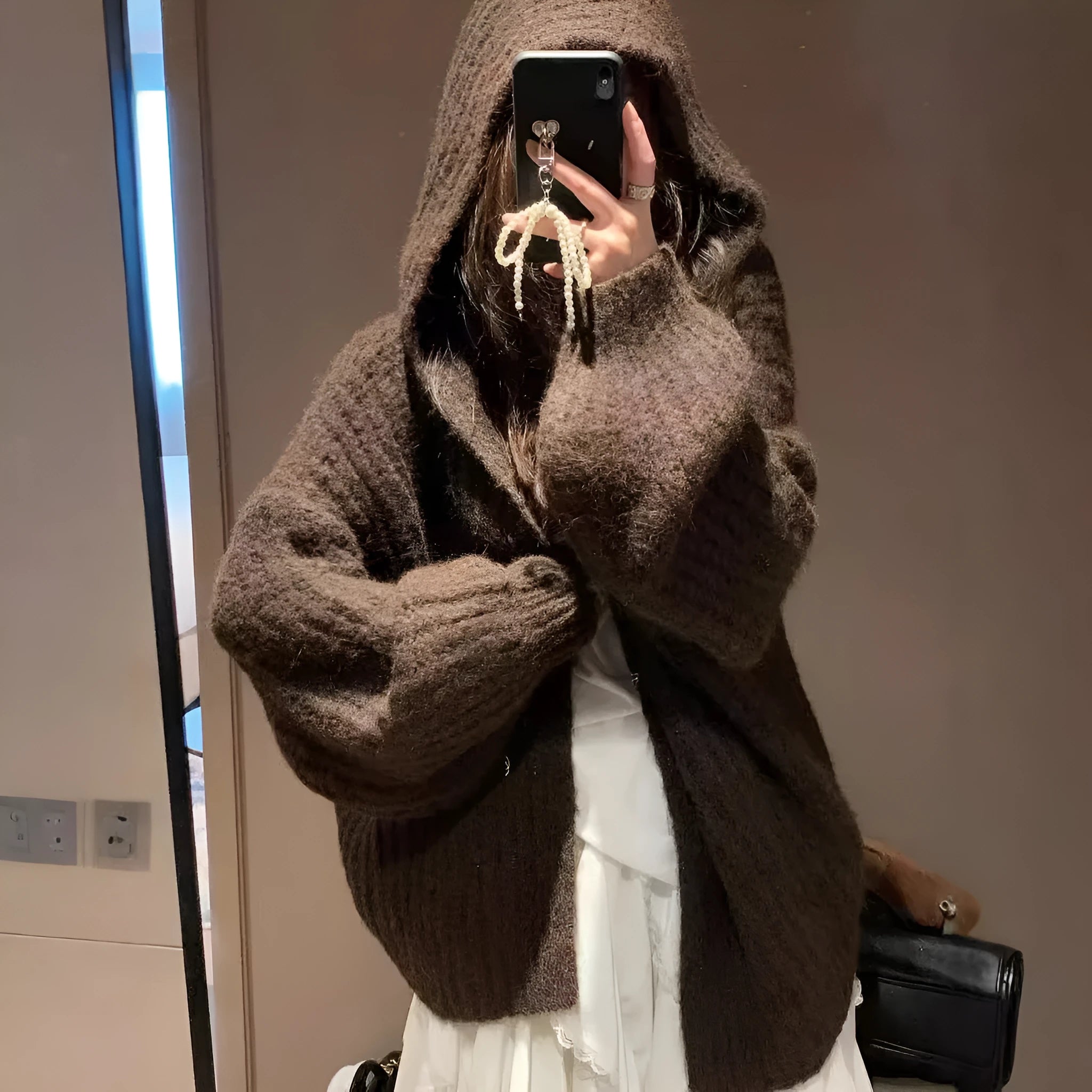 A woman wearing a brown retro-style hooded cardigan with thick knit fabric.