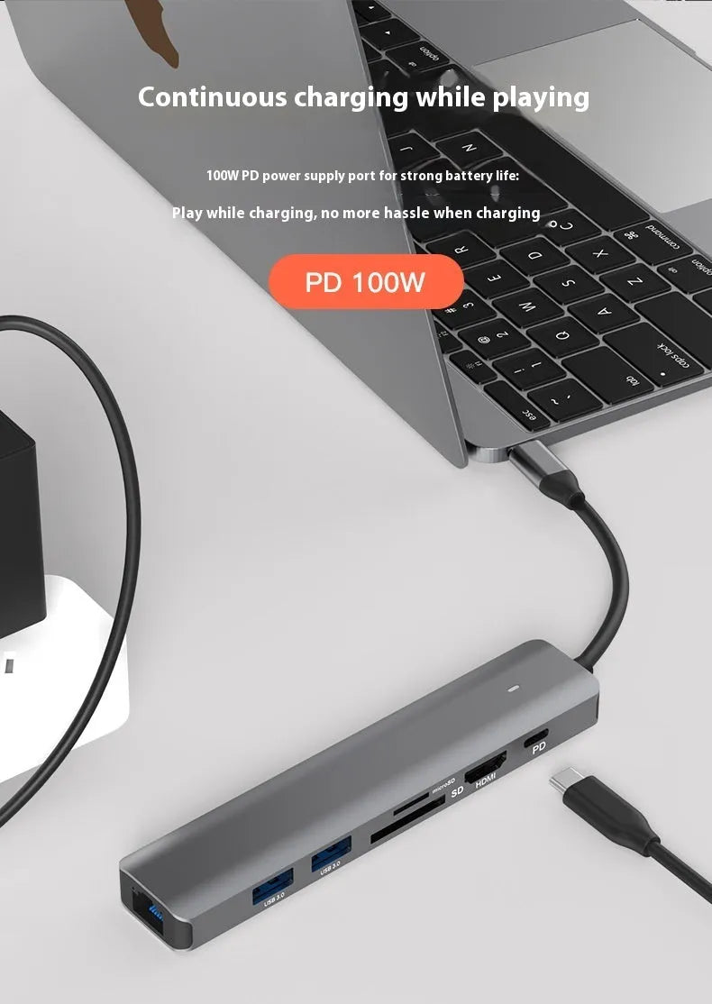 7-in-1 USB C card reader hub with multiple ports and SD card slots on a desk next to a laptop.