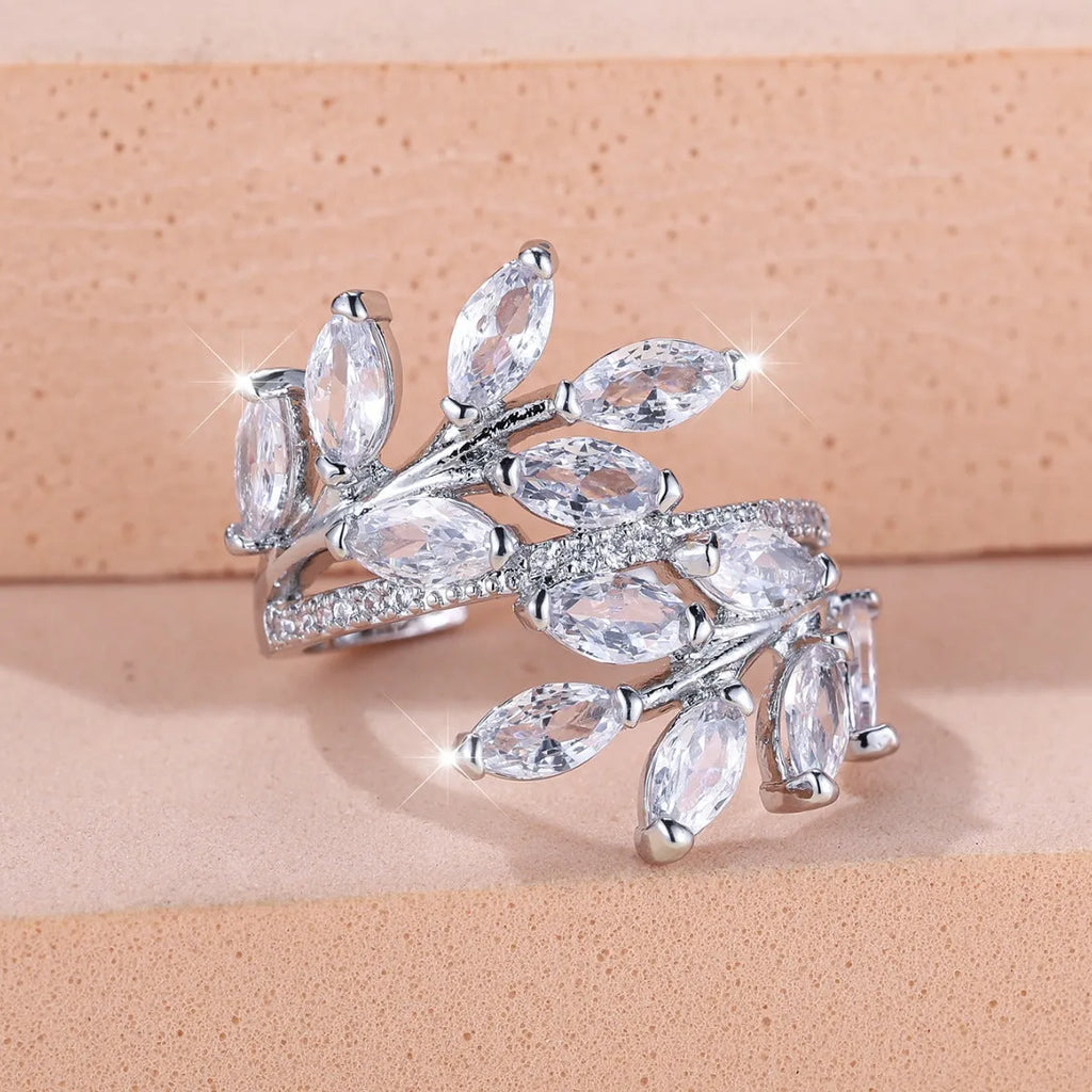 Adjustable open-ended leaf-shaped ring with zirconia stones on a copper band.