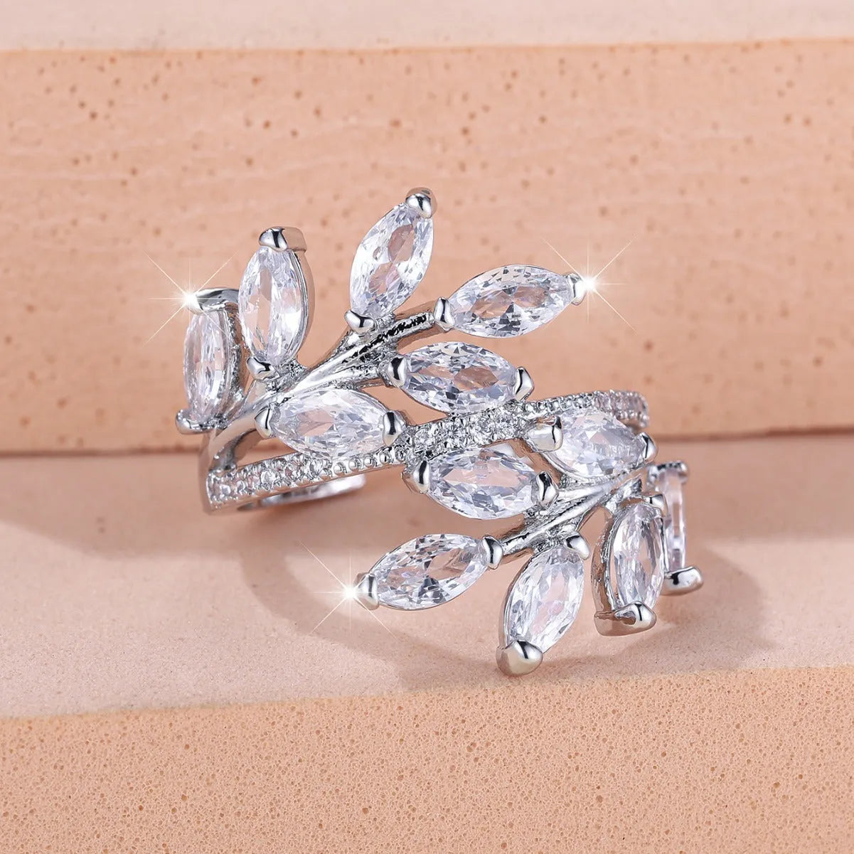 Adjustable open-ended leaf-shaped ring with zirconia stones on a copper band.