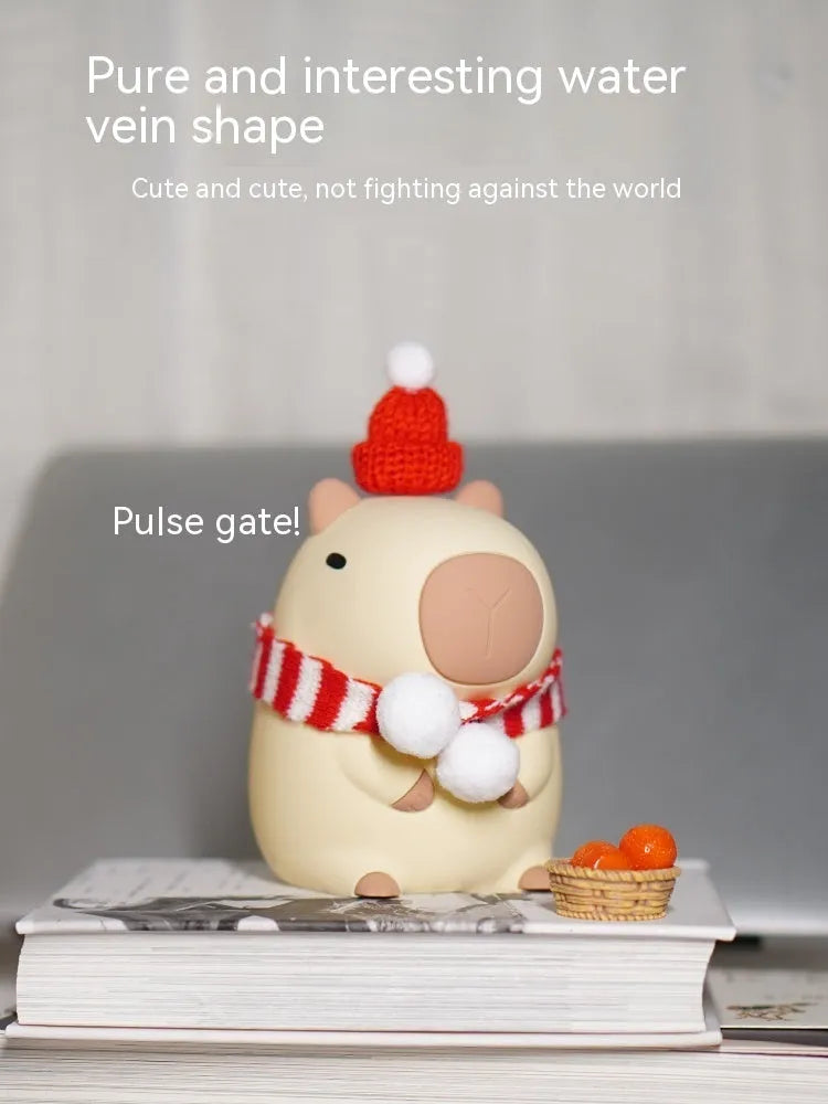 Small grey capybara-shaped silicone night lamp on a table.