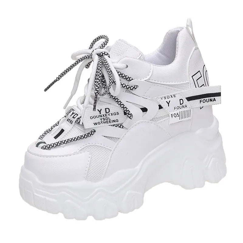 White and black women's low-top platform sports shoes with a cross strap and mesh upper.