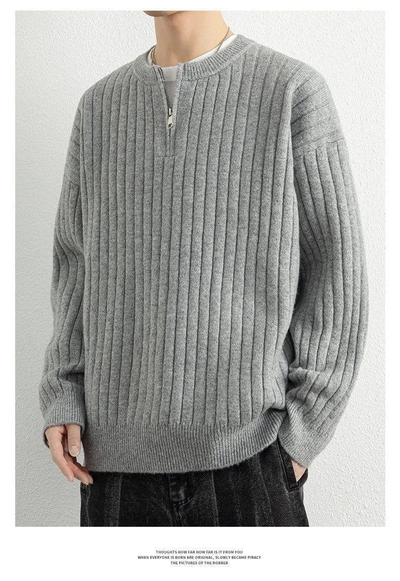 Man wearing a grey textured knit half-zip sweater with a loose fit and long sleeves.