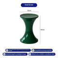 Green plastic hourglass-shaped shoe changing stool on a wooden floor.