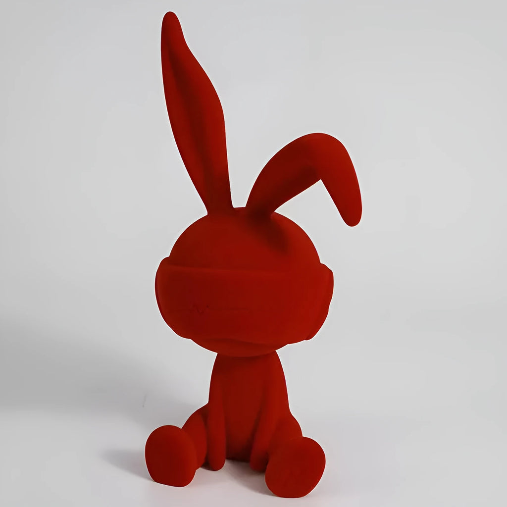 Small green resin suede blindfold rabbit table ornament on a wooden surface