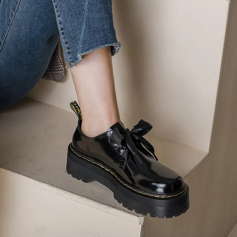 Women's thick-soled leather shoes with decorative ribbon cross-straps in black colour option