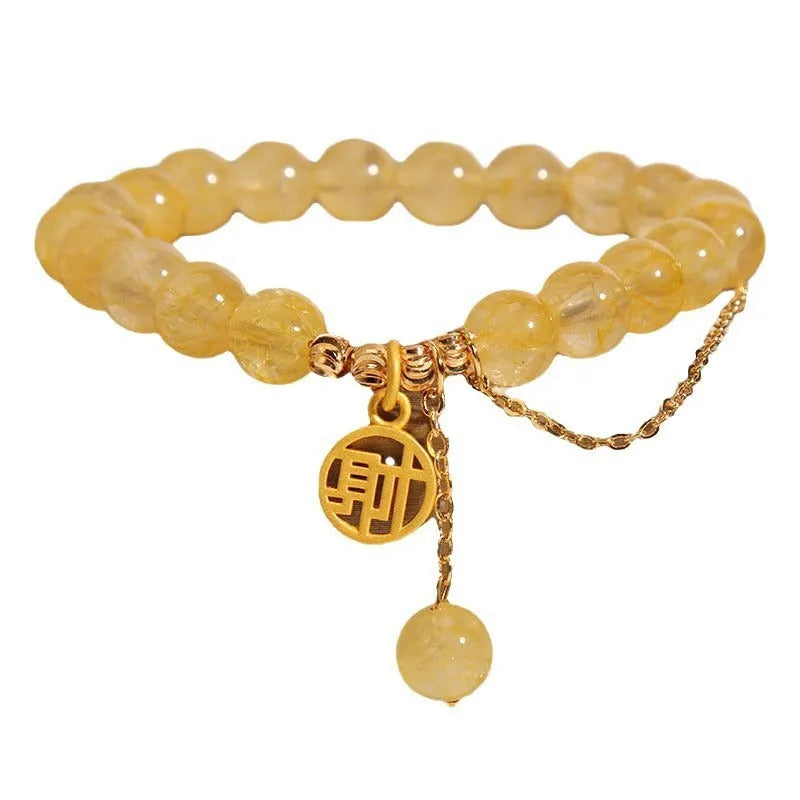 Women's natural citrine bracelet with a gold-tone Chinese character charm and tassel on an adjustable chain.