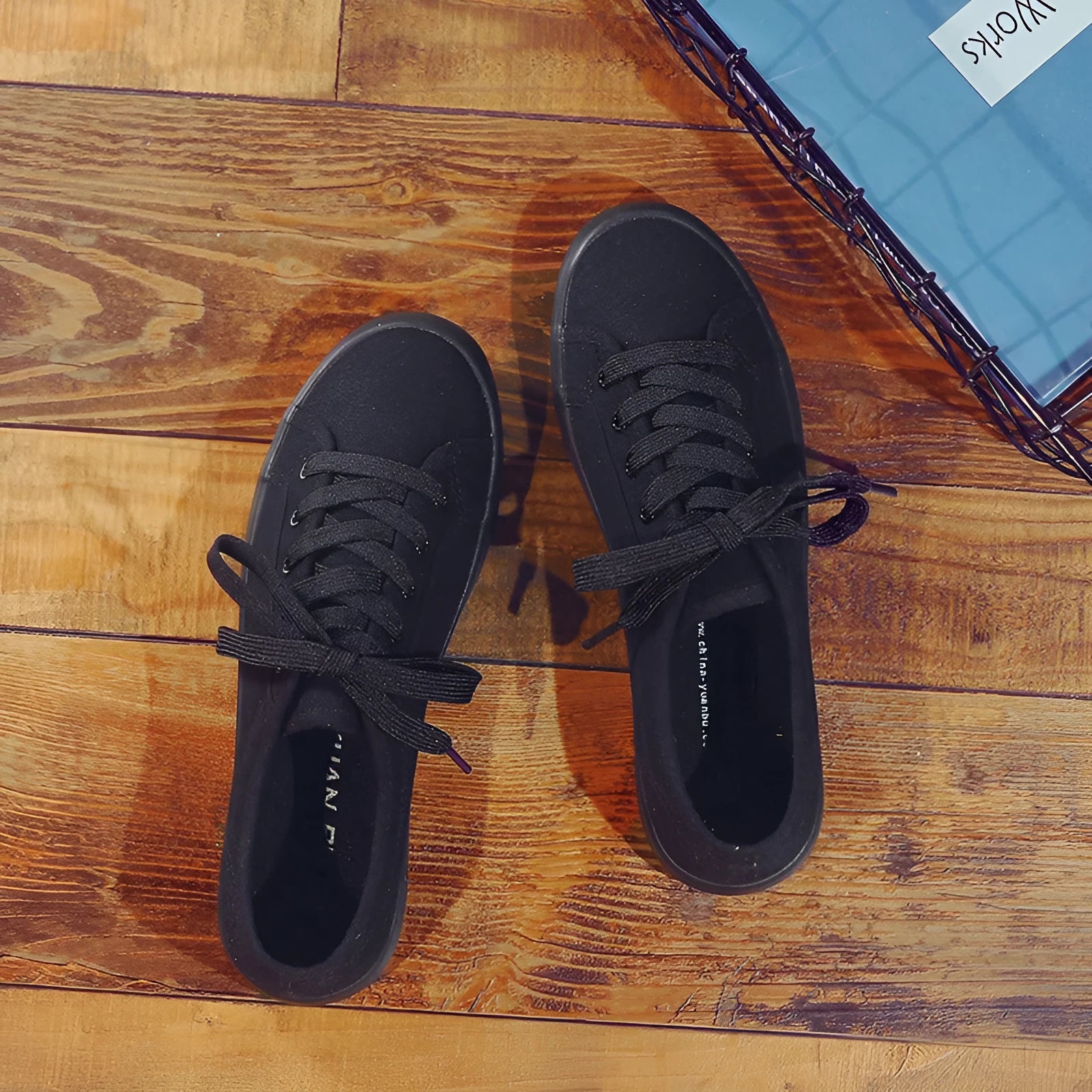 All black low top canvas lace-up shoes with a flat rubber sole for women.