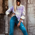 Lilac plaid print loose knit sweater with ribbed cuffs and hem on a hanger.