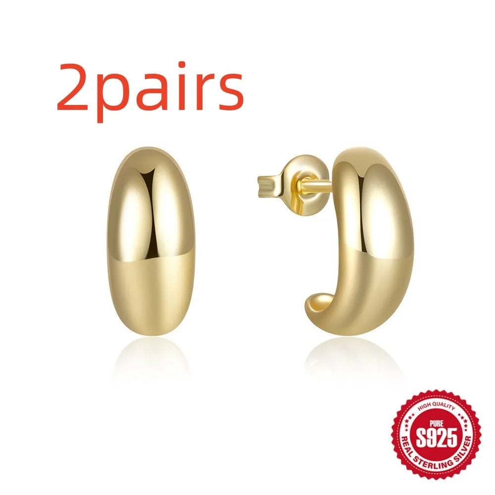 A single glossy C-shaped sterling silver stud earring on a white background.