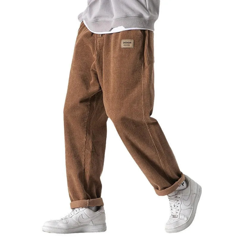 Men's loose straight corduroy sports trousers in army green colour on a hanger