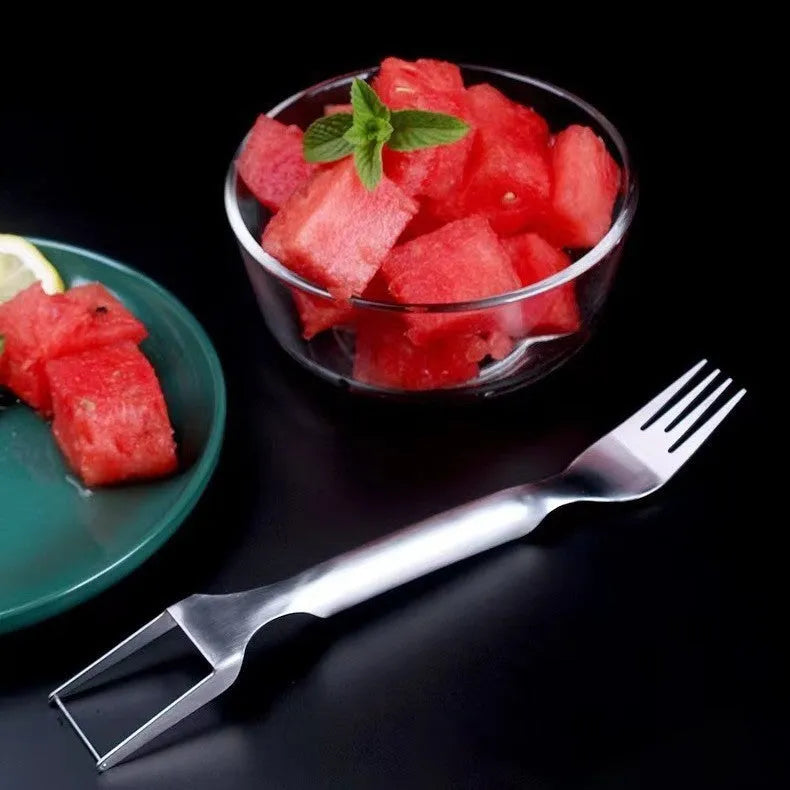 Silver stainless steel watermelon slicer and serving fork on a kitchen counter