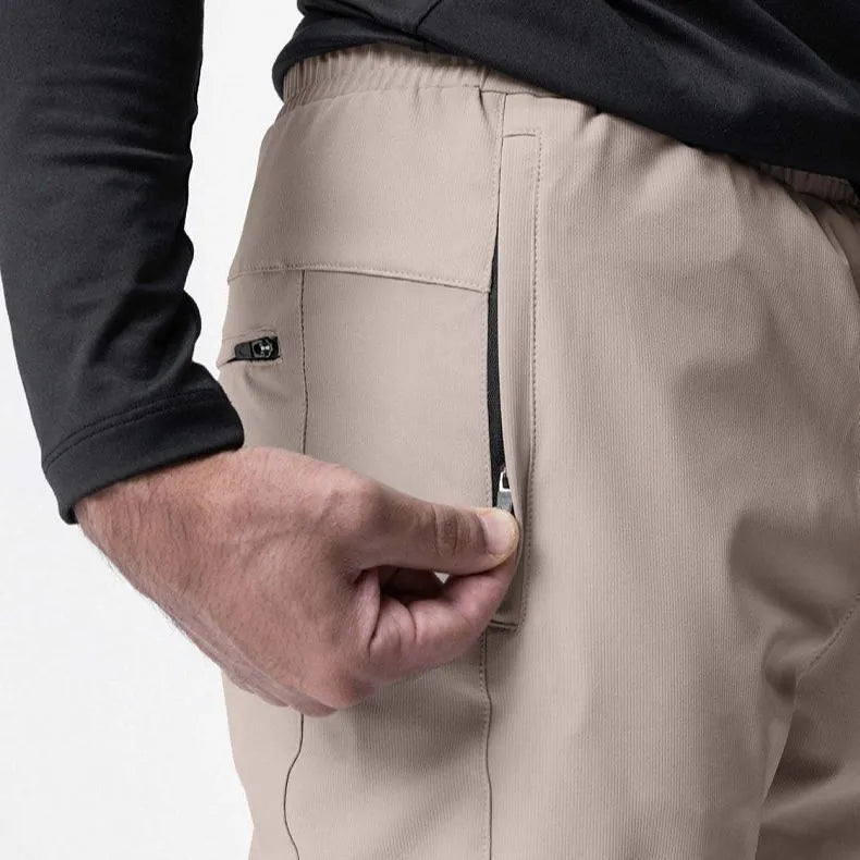 Men's loose grey running pants with ankle ties, laid flat to show mid-waist and full-length design.
