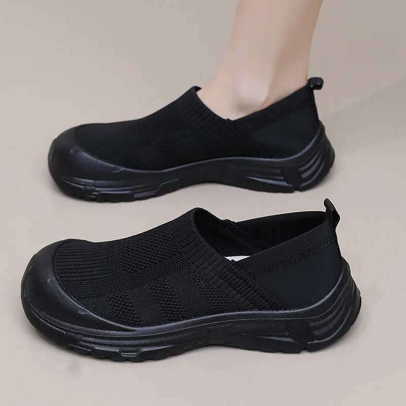 Women's beige, black and purple slip-on shoe covers with cloth upper and flat PVC sole.