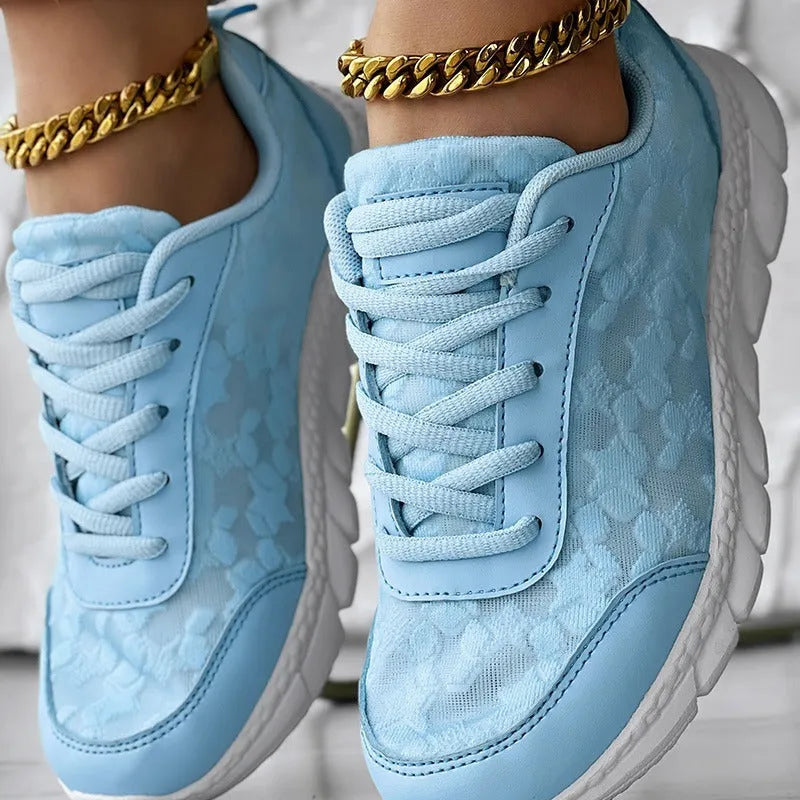 Women's white canvas running shoes with flat heel and round toe on a light background.