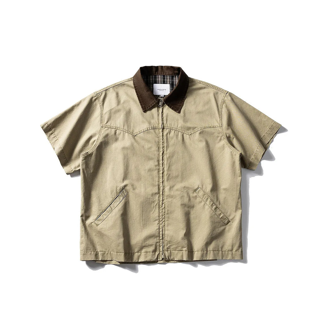 A loose grey or khaki cotton short-sleeved overall shirt, shown as an oversized cardigan style.
