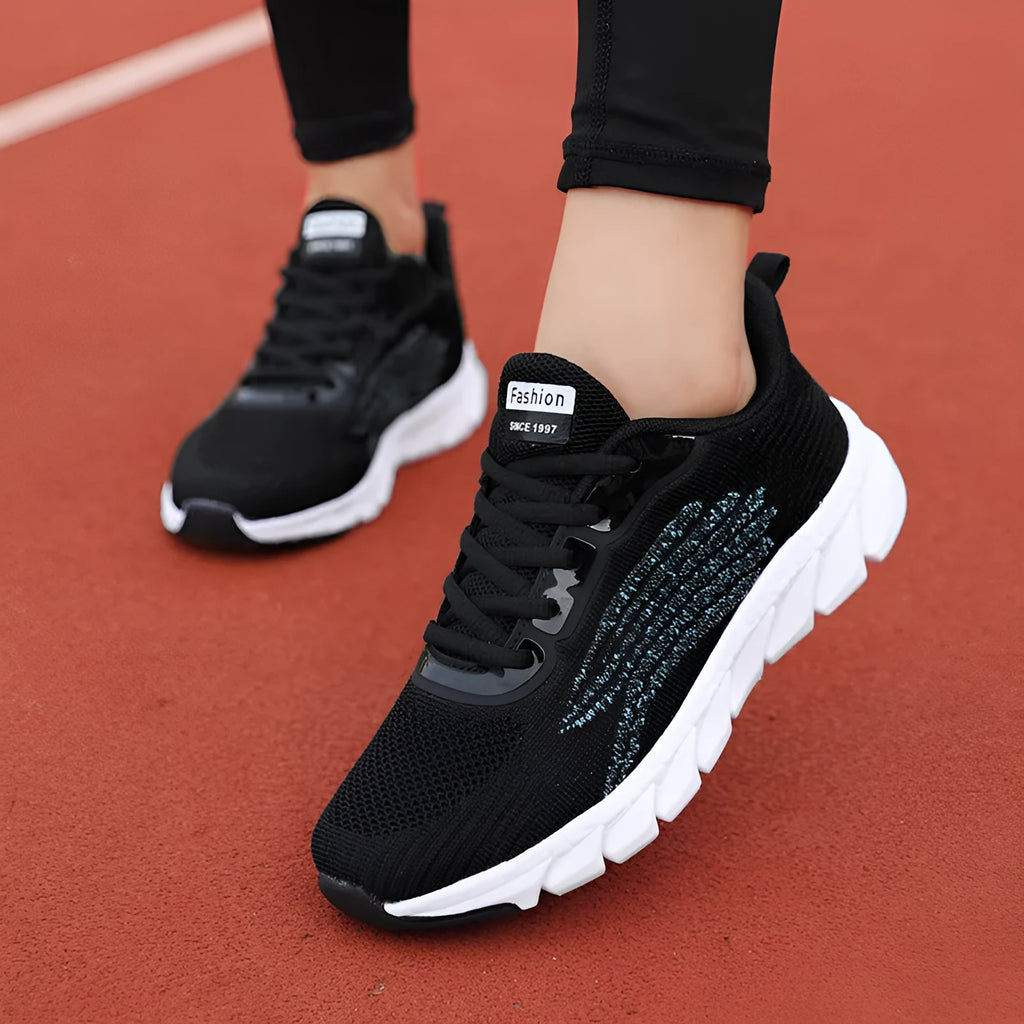 Women's black and white running shoes with cross strap detail and MD shock absorption sole