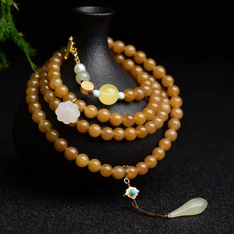 Close-up of a women's green jade bracelet with 6mm beads, beeswax, and leaf charms on a wrist.