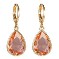 Carved geometric Saturn-shaped glass water drop earrings with copper details on a model.
