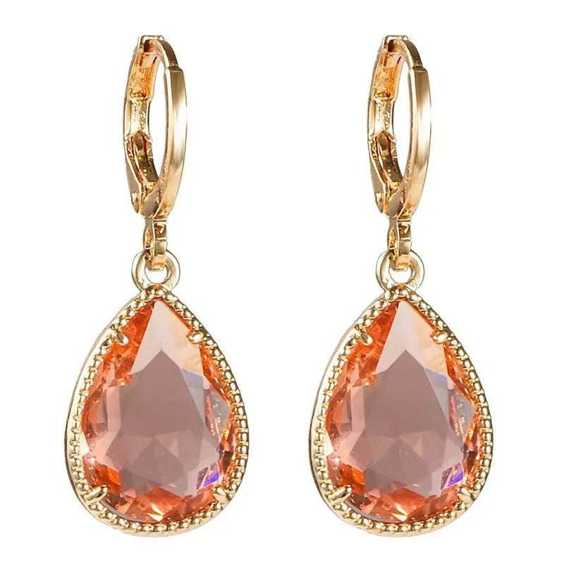Carved geometric Saturn-shaped glass water drop earrings with copper details on a model.