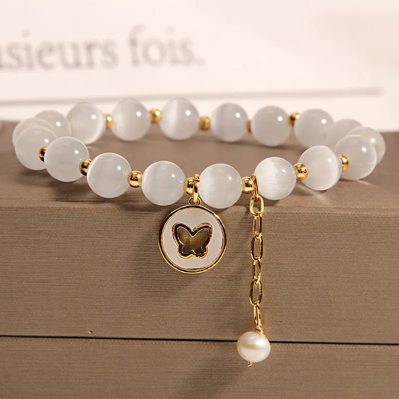 White Korean-style geometric bracelet with a cat's eye crystal on a stretch elastic band.