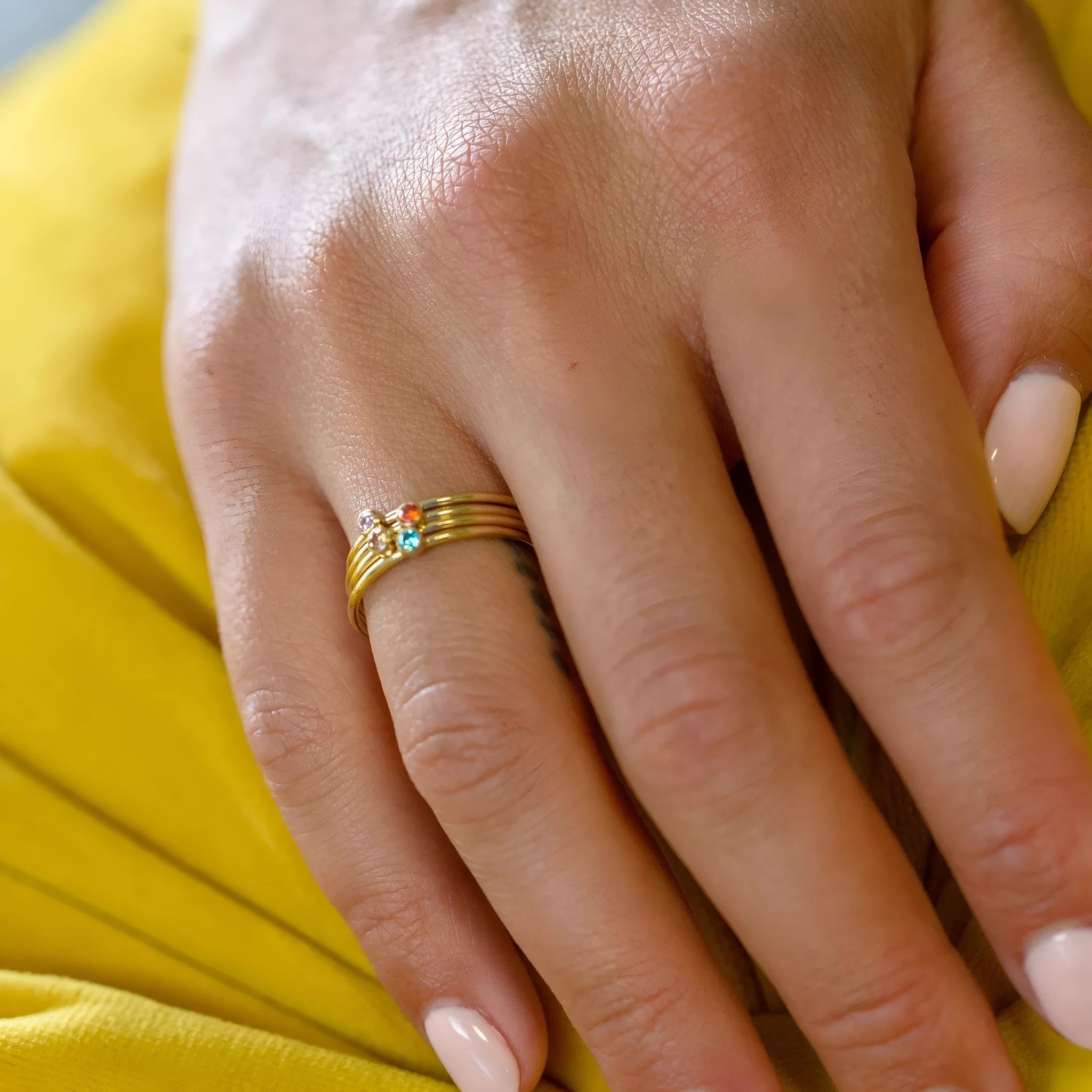 Geometric titanium steel ring with engraved detail and December birthstone colours on a white background