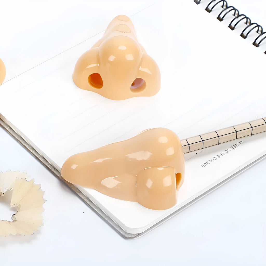 Flesh coloured plastic pencil sharpener with geometry shape on a white background.