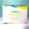 A5 habit tracking planner book open on a table, showing interior pages for schedule recording.