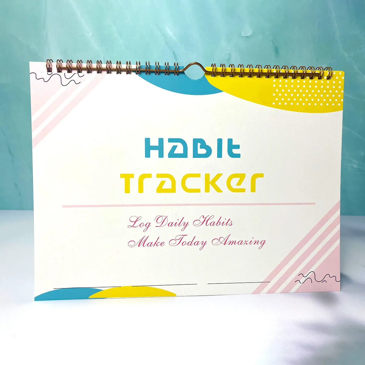 A5 habit tracking planner book open on a table, showing interior pages for schedule recording.
