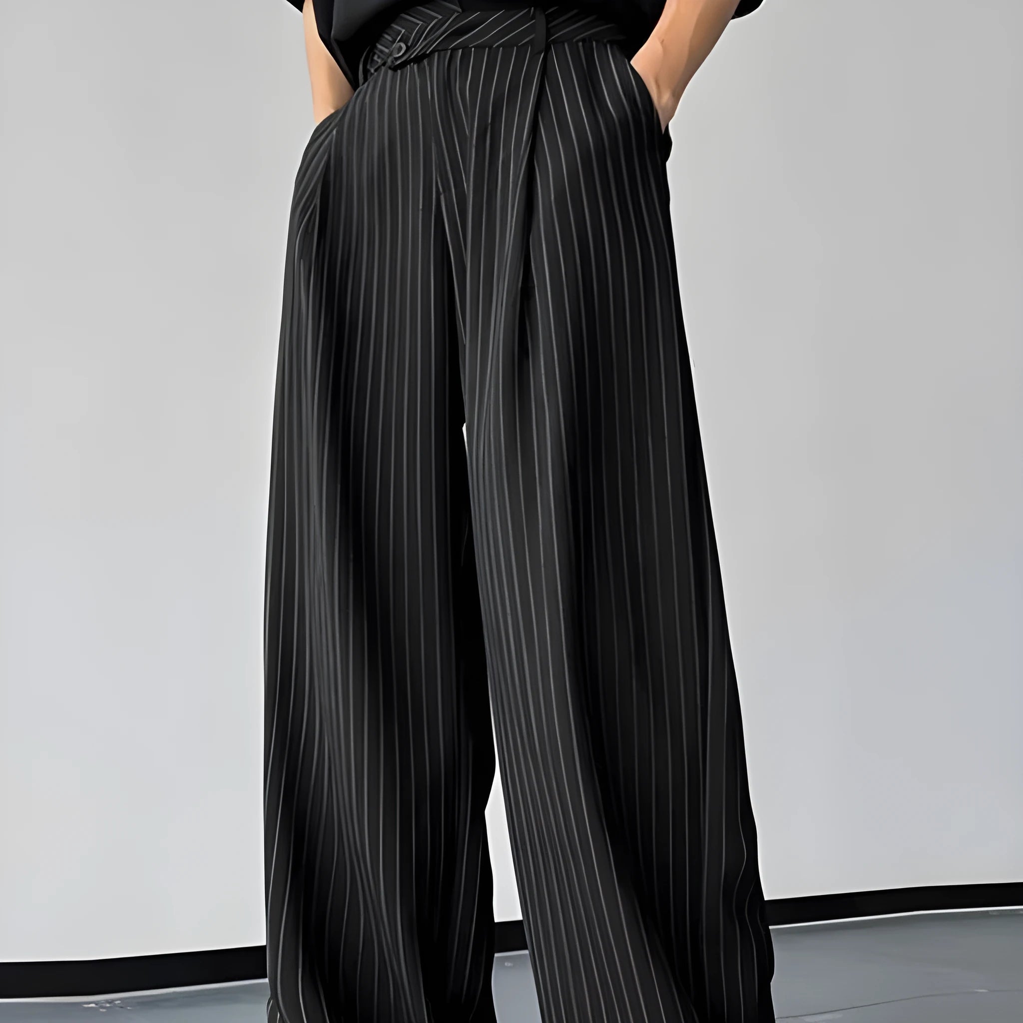 Men's black vertical striped pleated casual trousers showing elastic construction detail