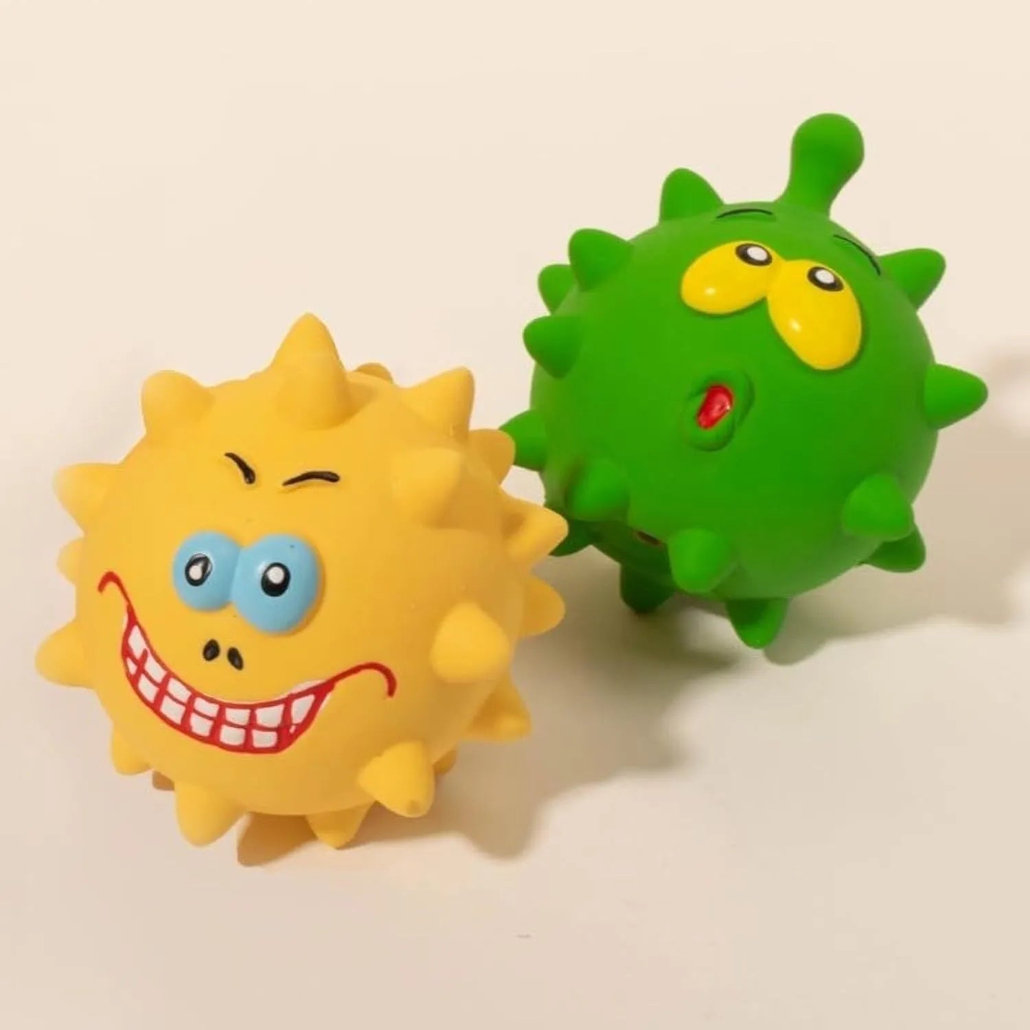 Four coloured natural latex squeaky dog balls with bumpy texture and cute faces