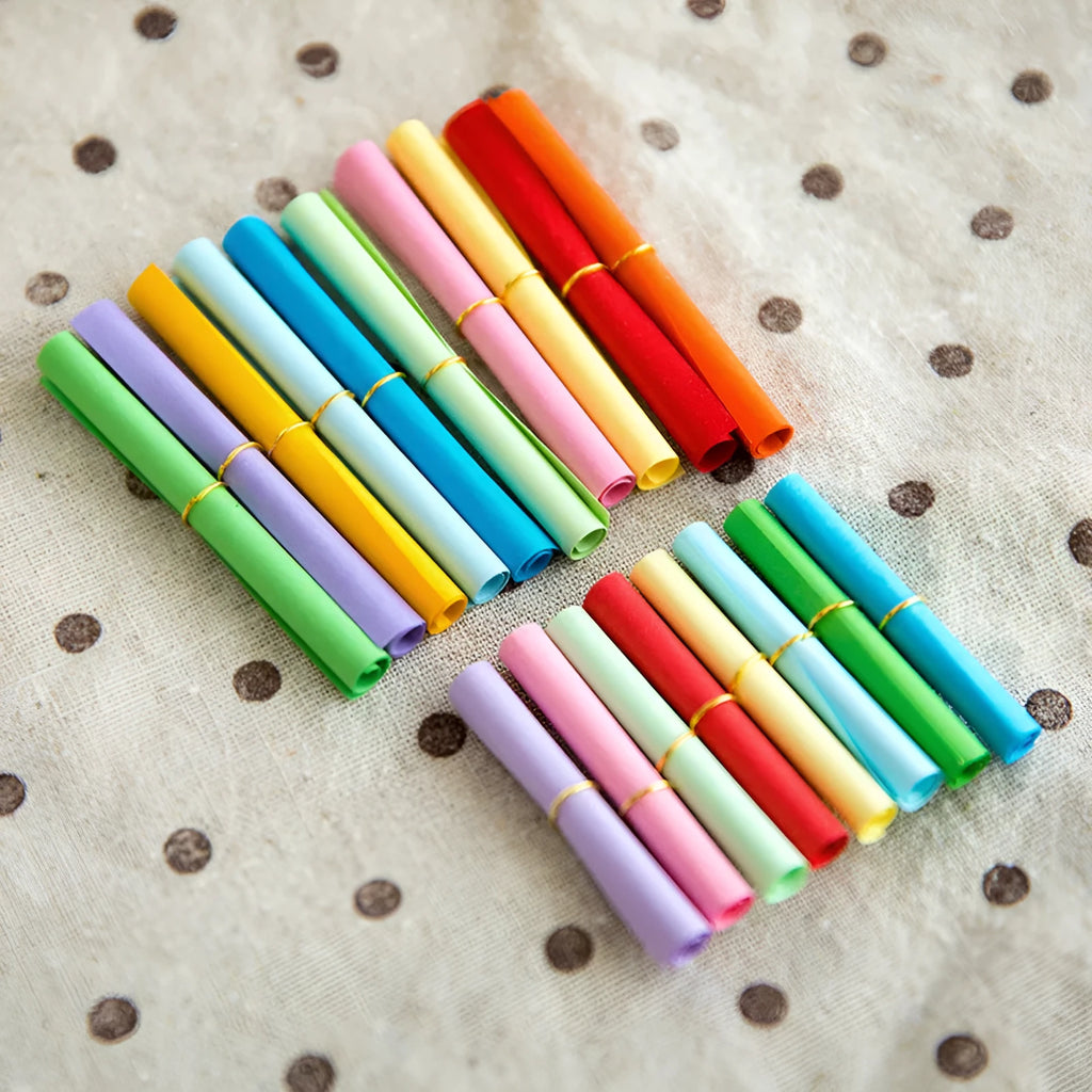Assorted colourful mini paper scrolls with metal eyelets, shown in 3x7cm, 4x7cm and 5x5cm sizes