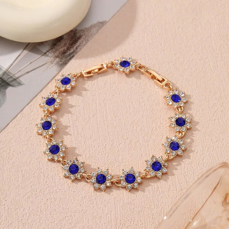European style electroplated bracelet with flower-shaped coloured gemstones on a metallic chain.