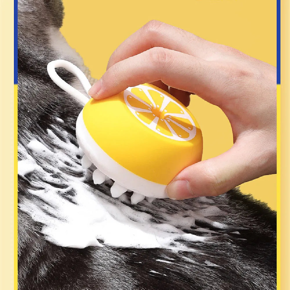A yellow soft silicone pet bath brush with a 3D massage head on one side and a comb on the other, shown on a blue background.