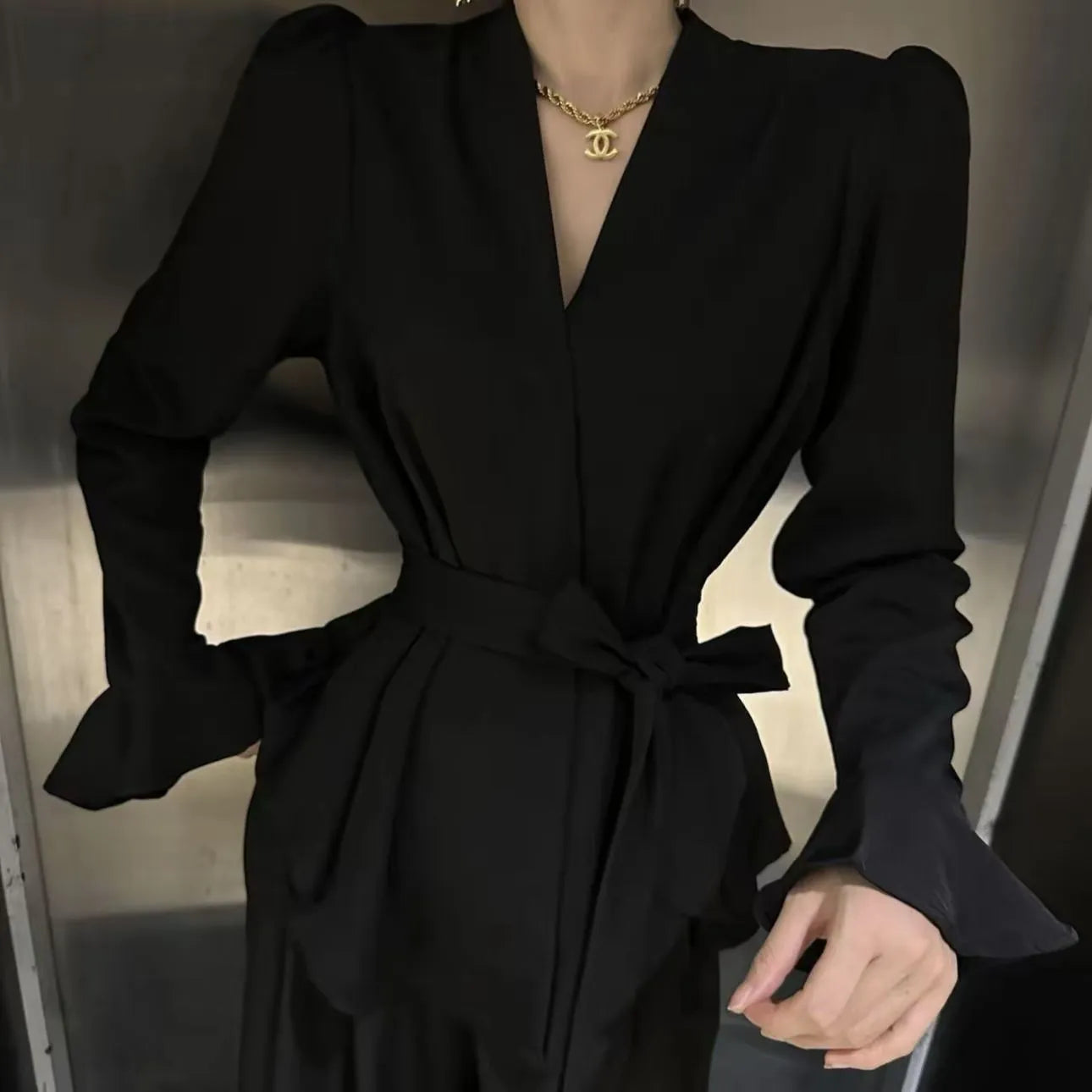 Women's black French-style shirt with an irregular collar and long bell sleeves.