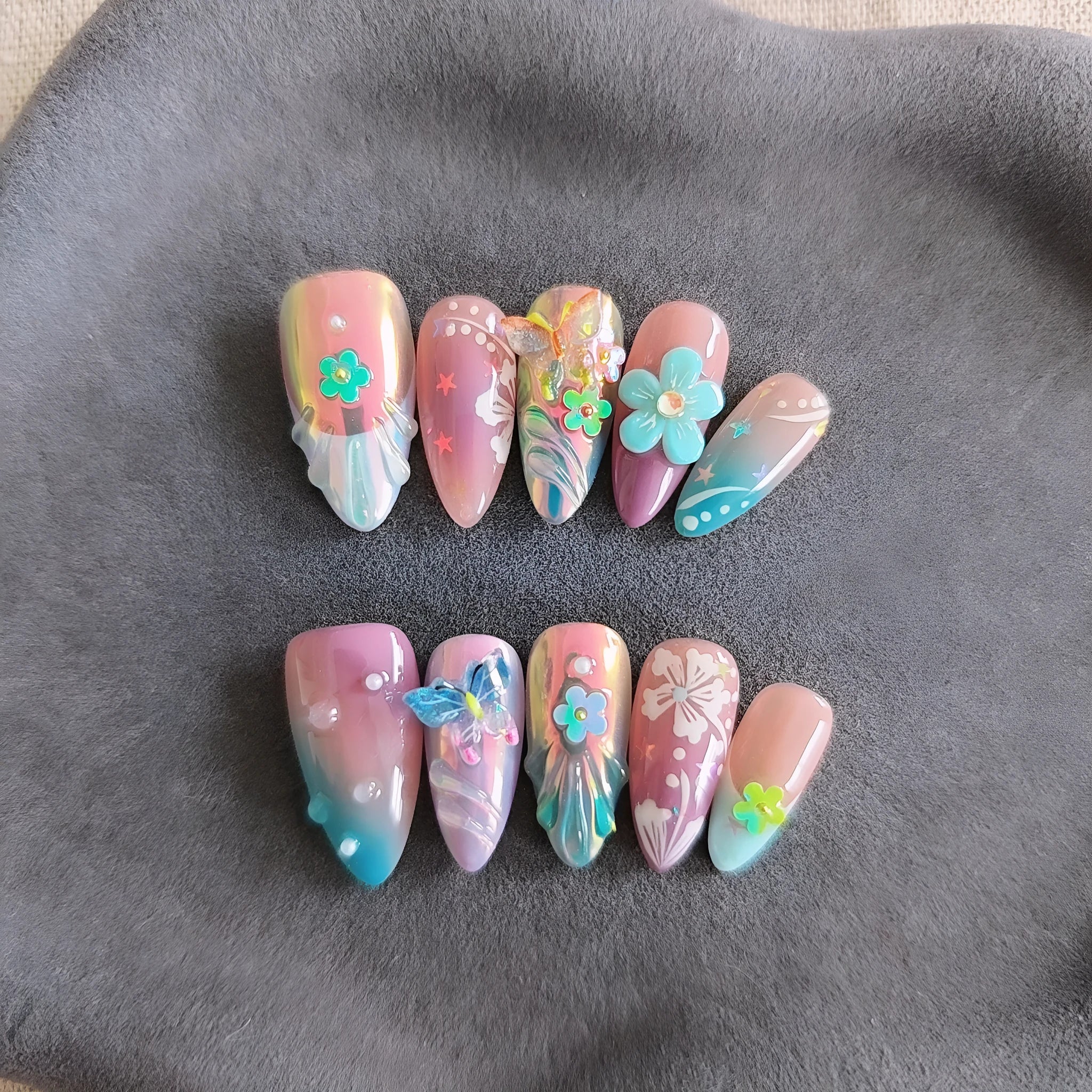Handmade press-on false nails with embossed colourful small flowers and butterfly designs in almond shape.