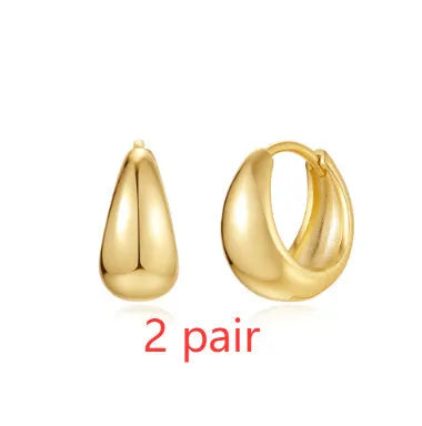 Geometric brass earclip earrings with a gold electroplated finish and round design details.