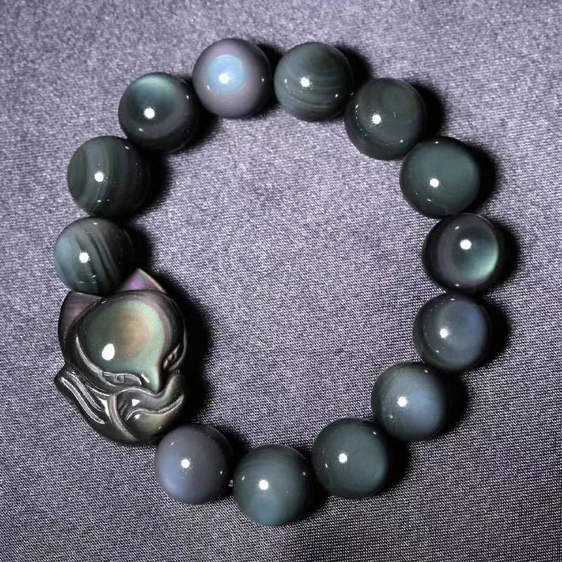 Obsidian stone bracelet with carved fox design in cartoon style, showing dark stone colouration